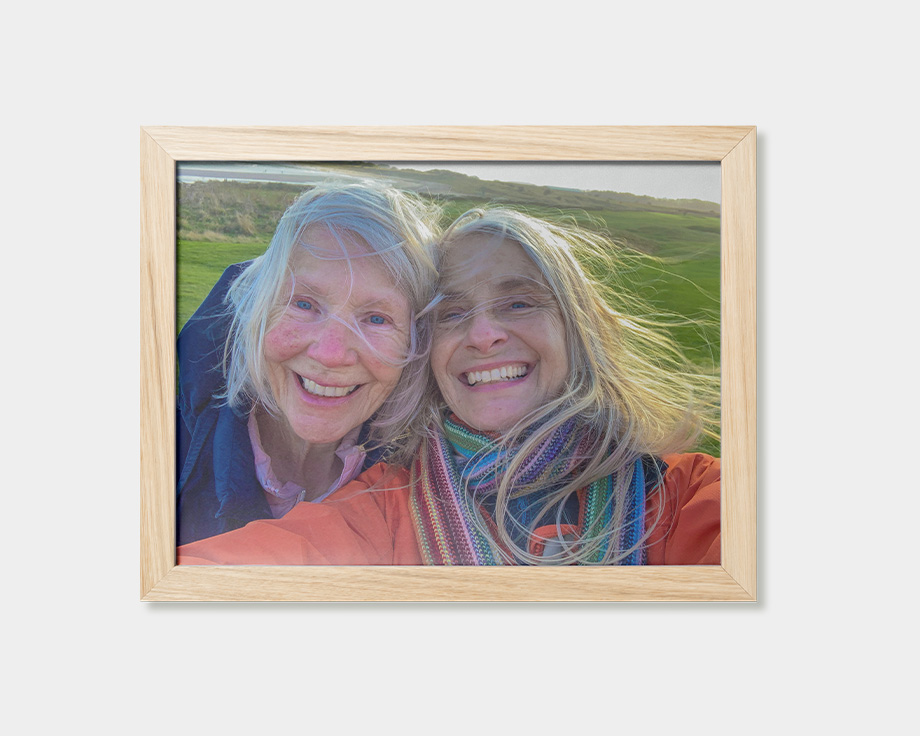 En indrammet plakat med et billede af to smilende kvinder