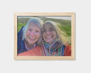 En indrammet plakat med et billede af to smilende kvinder