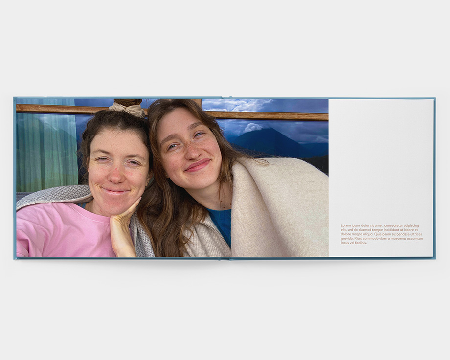 En åben layflat-fotobog med et billede af to smilende kvinder
