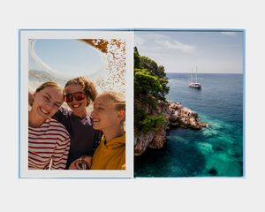 En stående L fotobog med et billede af en person, der kigger ud på en bjergsø