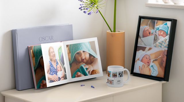 Personlige gaver til baby med en fotobog og vægdekorationer.