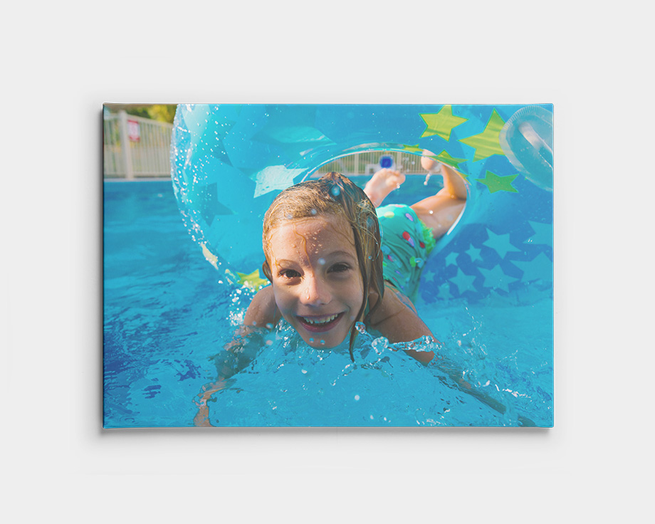 Fotolærred med et barn, der svømmer under vandet i en pool.